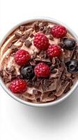 Creamy dessert topped with fresh raspberries and chocolate shavings on a bright background photo