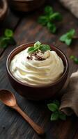 Creamy dessert topped with mint leaf and cocoa in wooden bowl surrounded by fresh mint on dark wooden surface photo
