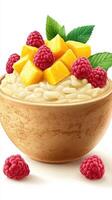 Bowl of creamy dessert topped with fresh mango, raspberries, and mint leaves depicting a summer treat in a cozy setting photo
