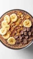 Delicious breakfast bowl featuring banana, granola, and chocolate chunks in a healthy meal option photo