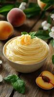 Creamy peach dessert served in a bowl surrounded by fresh peaches and mint leaves on a wooden table photo