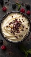 Creamy dessert topped with chocolate sprinkles, berries, and mint on a rustic surface photo
