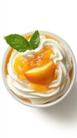 Creamy dessert with fresh peach slices and vibrant peach topping in a bowl on a white background photo