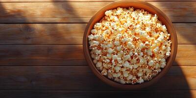 Bowl of fresh popcorn on wooden table ready for movie night at home in cozy living room setting photo
