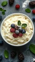 Delicious dessert bowl filled with whipped cream and fresh berries garnished with mint leaves on a textured surface photo