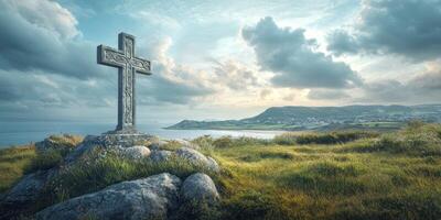 Celtic cross stands on a hill overlooking the ocean under a dramatic sky during golden hour in a coastal location photo