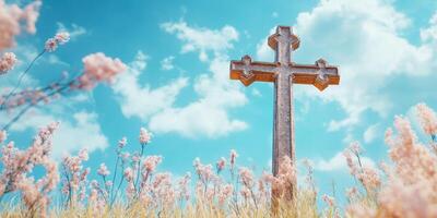 Cross stands tall among blooming flowers under a bright blue sky with fluffy clouds during a peaceful afternoon photo