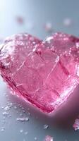 Heart-shaped pink ice cube rests on a smooth surface surrounded by scattered ice fragments photo