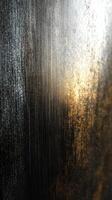 Descriptive close-up of textured surface with light reflecting off metallic finish during golden hour photo