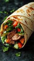 Delicious wrap filled with grilled meat and fresh vegetables on a dark background photo