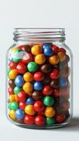 Colorful candy jar filled with vibrant chocolate-covered candies in various shapes and sizes photo