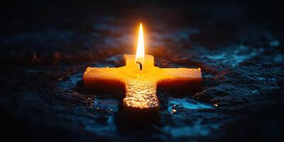 Candle illuminates a cross on a dark surface, symbolizing hope and faith in spiritual reflection photo