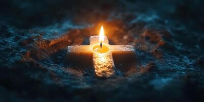 Candle illuminates a stone cross in a dimly lit space during a contemplative moment of reflection photo
