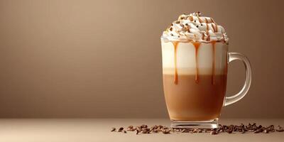 Creamy caramel latte topped with whipped cream and chocolate drizzle in a clear glass cup photo