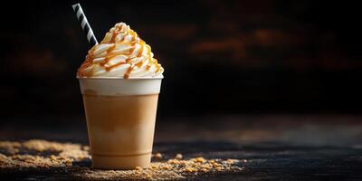 Delicious caramel milkshake with whipped cream and straw, served in a cup on a dark background photo