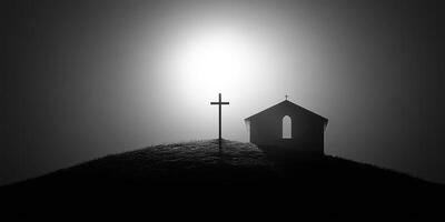 Silhouette of a small church and cross against a bright hazy background at sunrise photo