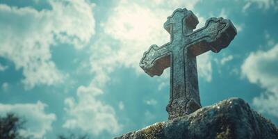 Old stone cross illuminated by sunlight against a backdrop of clouds in a tranquil outdoor setting photo