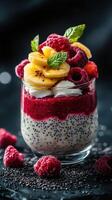 Delicious layered dessert with chia seeds, coconut cream, fresh bananas, and raspberries on a dark background photo