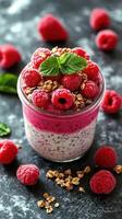 Delicious raspberry chia pudding with fresh fruits and crunchy granola on a dark background photo