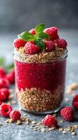 Delicious raspberry parfait layered with granola and fresh berries in a reusable jar photo