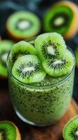 Refreshing kiwi smoothie in a glass garnished with fresh kiwi slices on a wooden surface photo