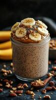 Delicious banana chia seed pudding topped with nuts and banana slices served in a glass jar photo