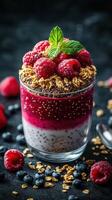 Delicious layered dessert with raspberries, blueberries, and granola in a clear glass on a dark background photo