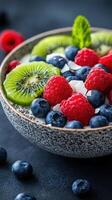 Colorful bowl of fresh fruit and yogurt with berries and kiwi on a dark background photo