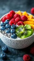 Fresh fruit bowl with blueberries, raspberries, kiwifruit, and orange slices prepared for a healthy breakfast photo
