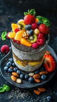 Fresh fruit parfait with chia seeds and nuts served on a dark slate plate photo