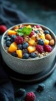 Healthy fruit and granola bowl featuring fresh berries and mango on a dark background photo