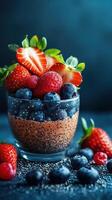 Delicious chia pudding topped with fresh berries in a glass cup on a dark background photo