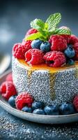 Delicious dessert featuring chia pudding topped with fresh raspberries and blueberries served on a plate photo