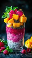 Colorful layered dessert with fresh fruits and chia seeds displayed in a glass photo