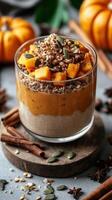 Creamy pumpkin parfait topped with granola and fresh fruit in autumn setting with decorative pumpkins photo