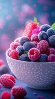 Freshly picked berries in a white bowl on a blue surface with a colorful, dreamy background photo