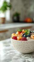 Delicious fruit bowl with fresh berries and mint served on a marble countertop in a modern kitchen photo