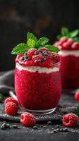 Delicious raspberry dessert with fresh mint served in an elegant glass on a dark background photo
