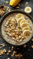 Delicious breakfast bowl filled with banana, oats, and chia seeds topped with crunchy granola photo