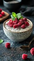 Delicious chia pudding topped with fresh raspberries and mint on a dark stone background photo