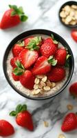 Delicious bowl of chia seed pudding topped with fresh strawberries and oats on a marble countertop photo