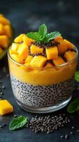 Delicious mango chia pudding with fresh mango chunks and mint on a dark background photo