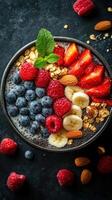 Colorful fruit and granola bowl with fresh berries and nuts served in a stylish black dish on a dark surface photo