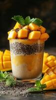Refreshing dessert made with mangoes, chia seeds, and mint leaves in a clear glass photo