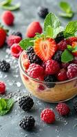 Fresh berry medley served in a bowl with mint leaves on a textured surface during daylight photo