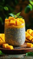Chia pudding topped with fresh mango cubes served in a glass on a wooden board in a natural setting photo