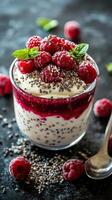 Delicious raspberry chia seed dessert with creamy yogurt and fresh mint on a dark marble background photo