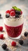 Creamy raspberry and blackberry dessert topped with fresh fruit and mint on a textured gray surface photo
