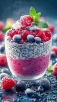 Delicious raspberry and blueberry parfait with chia seeds served on a blue background photo