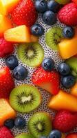 Colorful assortment of fresh fruits including strawberries, kiwi, and blueberries on a textured background photo